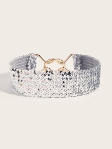 Detail of silver sequin belt for dresses with gold interlocking buckle and elastic band