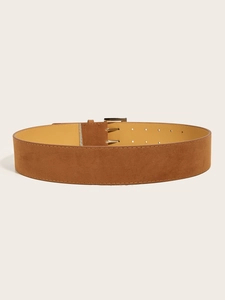 Detail of vintage brown suede wide belt with metal buckle and adjustable pin holes