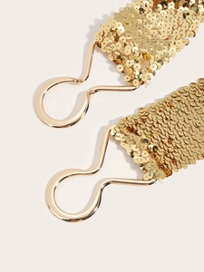 Detail of gold sequin elastic waist belts with metallic wave-shaped hook closures