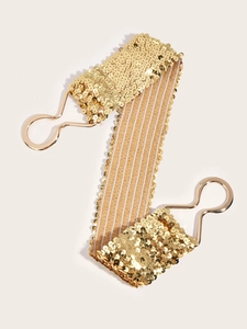 Detail of a gold sequin elastic waist belt with metallic hook closure for women