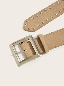 Dettaglio cintura scamosciata beige con fibbia quadrata argento e rivetti a borchie