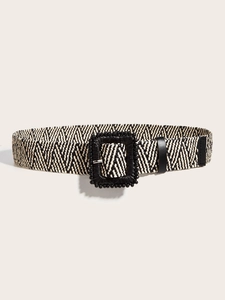 Dettaglio di cintura intrecciata con motivo chevron bianco e nero e fibbia quadrata