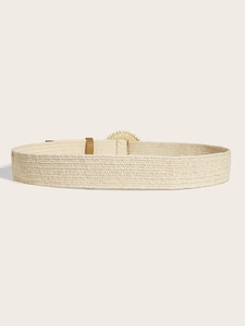 Dettaglio della cintura intrecciata in paglia beige con fibbia decorativa con perline