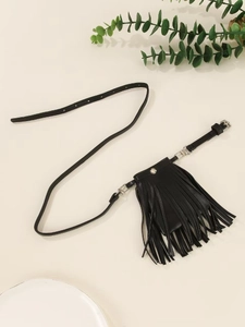Détail d'un sac de taille punk noir avec de longues franges et bouton pression argenté