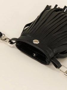 Détail d'un sac en cuir noir avec des franges et un fermoir à bouton-pression argenté