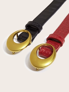 Detail of red and black crocodile embossed belts with large gold oval metal buckles