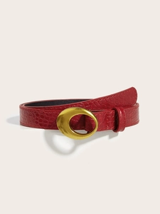 Detail of red faux crocodile leather belt with vintage oval gold metal buckle