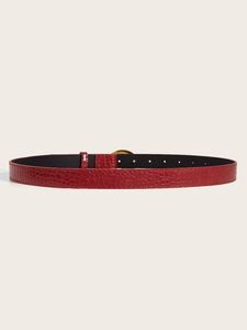 Close-up of deep red crocodile embossed leather belt with a vintage gold metal buckle
