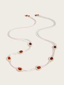 Détail de la ceinture bohème tressée avec perles d'ambre et cordons de coton crème