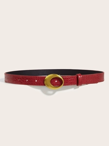 Detailed macro view of the burgundy crocodile pattern leather belt with a gold oval buckle