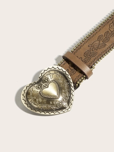 Detail of vintage heart buckle with floral relief and embossed brown leather belt strap