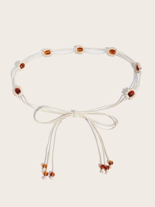 Détail de la chaîne de taille bohème tressée avec perles ambrées et corde en coton