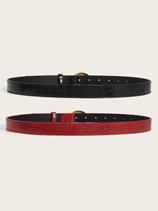 Detail view of burgundy and black belts featuring crocodile embossed texture and gold buckle
