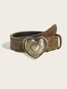 Close-up of bohemian brown belt featuring a large ornate heart buckle and gold studs