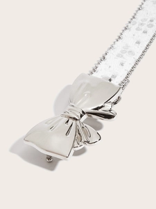 Close-up of silver butterfly buckle with sequined lace belt and delicate beadwork