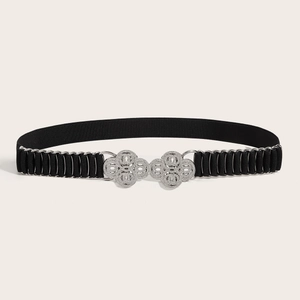 Detail eines schwarzen elastischen Taillengürtels mit silberner floraler Strass-Schnalle