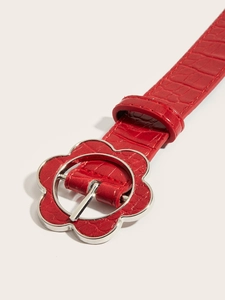 Detail of red crocodile texture belt with silver flower buckle and punk style metal studs