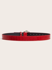 Close-up of red faux crocodile leather belt with designer silver metal floral buckle