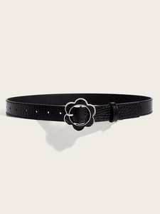 Close-up of black punk belt with crocodile texture and silver flower buckle