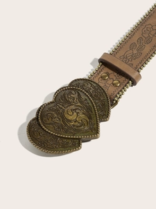 Detail of vintage heart-shaped buckle and embossed floral leather belt with chain edge