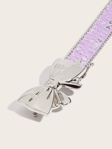 Detailed macro view of purple sequin fabric belt with silver butterfly metal buckle
