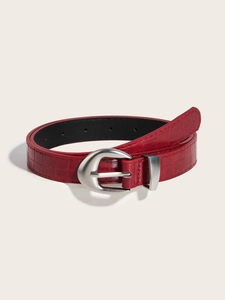Macro detail of red crocodile embossed leather belt with silver horseshoe buckle closure