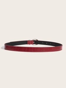 Detail shot of slim burgundy waist belt featuring faux crocodile texture and silver metal buckle