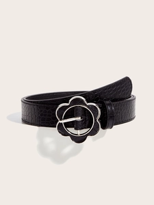 Detail of black crocodile embossed faux leather belt with a floral silver metal buckle