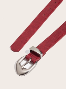 Detail of burgundy leather belt showing embossed crocodile texture and silver buckle