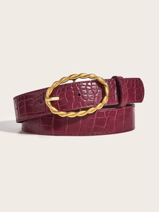 Detail of burgundy crocodile-embossed leather belt with a gold woven oval buckle