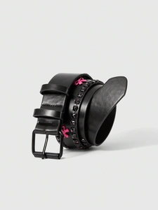 Detail of black punk leather belt with square studs and pink 3D bow decoration