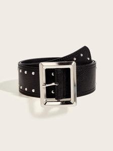 Close-up of black punk belt featuring silver studs and large rectangular metal buckle