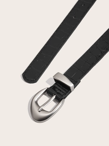 Detailed macro view of black crocodile pattern belt with silver semi-circular metal buckle