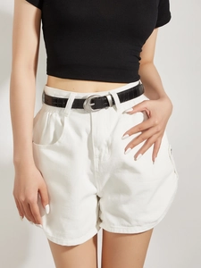 Detail of a thin black crocodile leather belt with oval buckle on white shorts