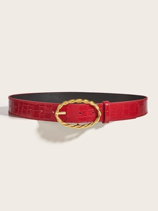 Detail of burgundy leather belt with crocodile texture and golden braided oval buckle