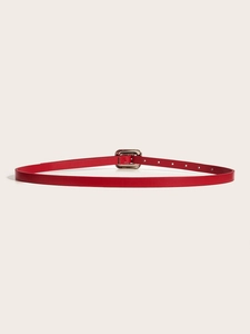 Gros plan d'une fine ceinture en cuir rouge avec boucle argentée rectangulaire