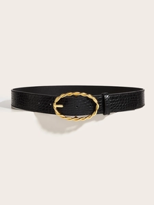 Detail view of black crocodile pattern leather belt with a golden twisted oval buckle