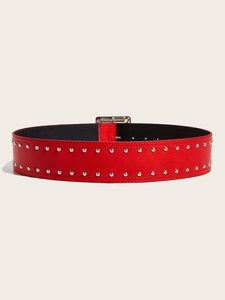 Close-up of a red leather punk belt featuring double-row silver rivets and square buckle