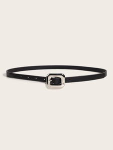 Détail d'une fine ceinture en cuir noir avec une boucle carrée en métal argenté poli