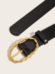 Close-up of black crocodile pattern belt with a textured golden oval buckle