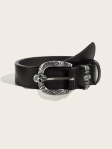 Close-up of black punk leather belt with vintage silver skull buckle and stitching
