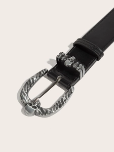 Close-up of gothic skull buckle and keeper on black punk leather belt for men