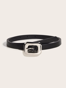 Détail d'une ceinture minimaliste en cuir noir avec une boucle rectangulaire en argent