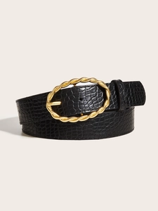 Detail of black faux crocodile leather belt with vintage gold twisted oval buckle