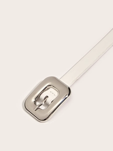 Gros plan sur une ceinture fine en similicuir blanc avec une boucle rectangulaire en métal poli