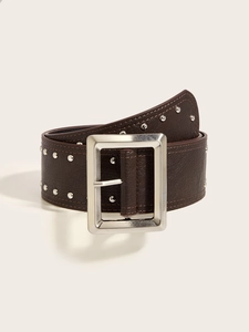 Macro view of a wide punk style brown belt with silver rivets and metal buckle