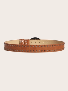 Détail d'une ceinture punk marron avec double rangée de rivets en métal et perforations