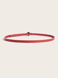 Close-up of a thin red leather belt with a round silver buckle and adjustable holes