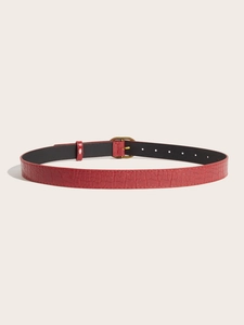 Detailed macro view of vintage red crocodile pattern leather belt with gold buckle