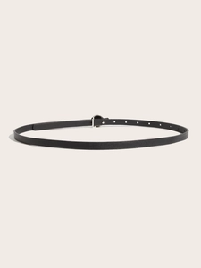 Detail of slim black leather belt featuring a classic round silver metal buckle for women